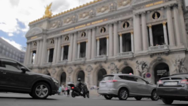PARIS, FRANCE- August 2018: Cars, cyclists and trucks, and high urban traffic against the background of an unrecognized beautiful building. In the background, a large number of unrecognized