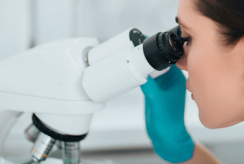 Technician using microscope in lab, close-up. Laboratory technician and microscope, macro