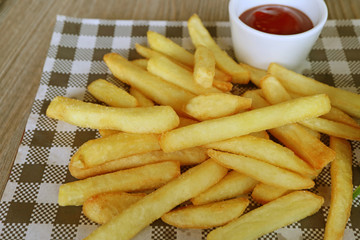 French fries with ketchup on the wooden table 
