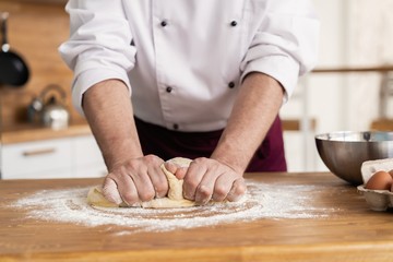 Making dough by male hands at bakery
