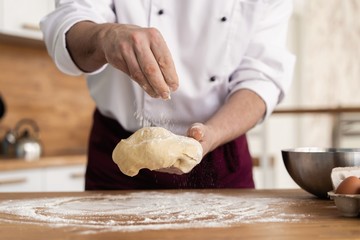 Making dough by male hands at bakery