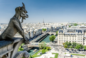 Notre-Dame de Paris. Famous Chimera demon overlooking the Eiffel Tower from Cathedral Notre Dame in...