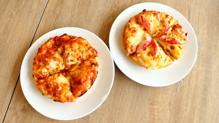 Pizza in a white plate on a wooden table background