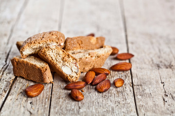 Fototapeta premium Fresh homemade Italian cookies cantuccini heap and almond seeds on ructic wooden table background.