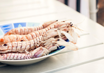 Boiled red shrimps prawns on the plate, seafood from the fish market of Catania, Sicily.