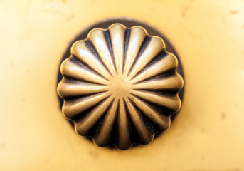 Exterior vintage door handle with a bronze finish on a wooden front door in historic building Catania, Sicily, Southern Italy.