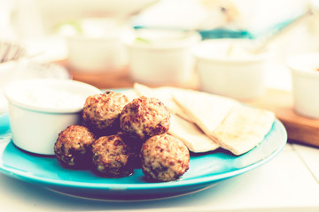 Fried minced meat with sauce and tortillas, traditional Greek lunch on a blue plate in a restaurantю