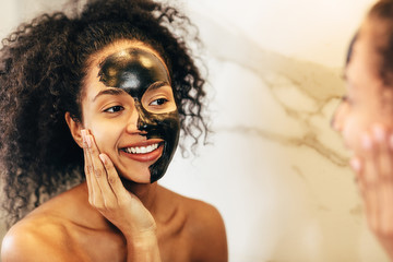 Happy woman admiring her skin after cosmetics mask