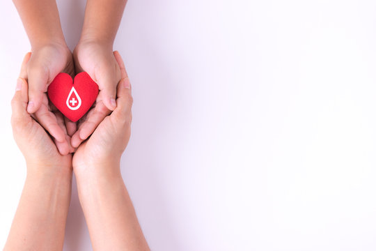 Woman and child hands holding red heart  for blood donation concept,World blood donor day, health care love, hope and family concept, world heart day,world health day. Copy space for advertisers.