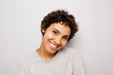 Close up happy young african american woman smiling white wall