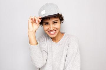 Close up happy young african american woman smiling with cap by white wall