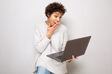 young woman with surprised expression when looking at laptop computer