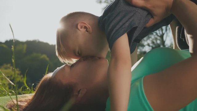 Mother and son having fun on the grass in a park