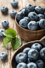 Blueberries in wooden spoon on old wood table. Healthy eating and nutrition concept.