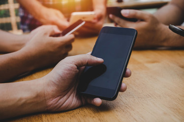 group of friends or young people hands using smart phone playing social networking sitting on table at home office, digital technology, WiFi internet, network connection and relationship concept