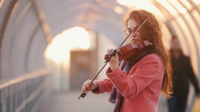 Talanted woman playing violin composition, in public