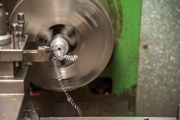 The lathe machine cutting the metal tube parts. The metal working manufacturing process.