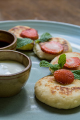 Cottage cheese pancakes with jam and sour cream. Russian syrniki or sirniki, cottage cheese fritters or pancakes served with jam and sour cream