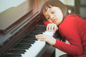 The girl bored to leaning piano