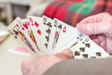 Elderly man hands holding playing cards shallow depth of field Close up shot