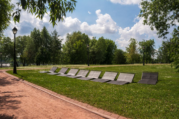 Sunbeds for relaxing in the Park. Green alleys and paths