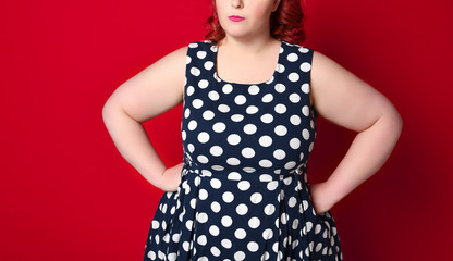 Closeup of a fat angry redhead woman holding her cheek by hand. pinup girl isolated .