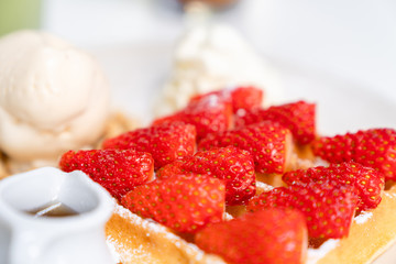 Closeup strawberry waffle with honey for topping
