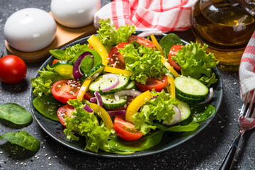 Fresh vegetables salad on black.