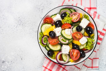 Greek salad in black plate on the table.