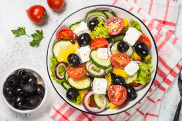 Greek salad in black plate on the table.