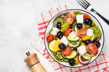Greek salad in black plate on the table.