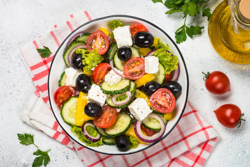 Greek salad in black plate on the table.