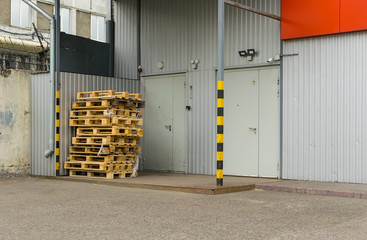 View on pallets, used containers, boxes in front of the door of the warehouse or store