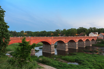 The old brick bridge over the Venta River in the evening. Kuldiga Latvia
