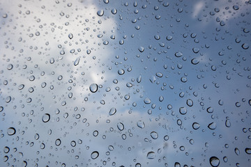 drop of water on window glass, cloud and blue sky background