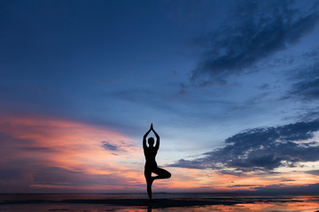 Silhouette photo of woman practicing yoga at sunset