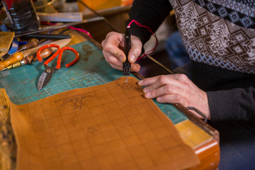 Skinner making decorative details on leather playing field
