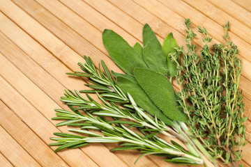 Collection of fresh herbs for cooking isolated on wooden background. Bunch of herbs