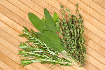 Collection of fresh herbs for cooking isolated on wooden background. Bunch of herbs