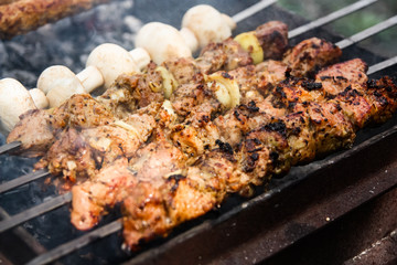 grilled meat and mushrooms on the grill. barbecue close up