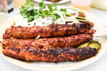 grilled lula kebab with herbs and onions on a plate