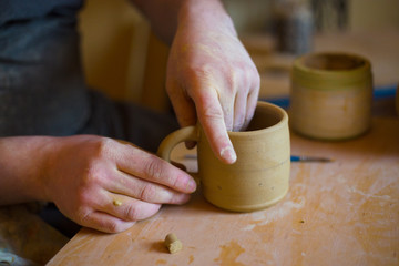 Professional male potter working in workshop, studio
