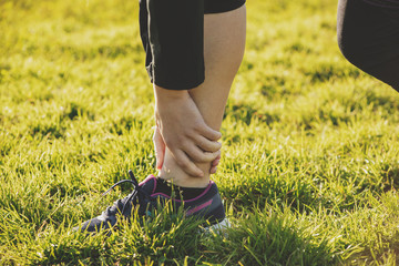 A person holds their leg in pain