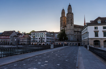 Naklejka premium Grossmunster Church by limmat river in Zurich old town at night