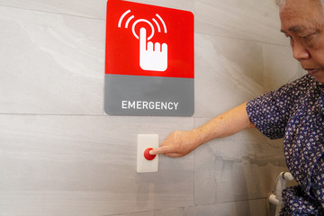 Asian senior or elderly old lady woman patient press emergency button in a special toilet bathroom...