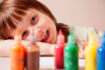 Happiness of child. Little cute girl laughing with coloured paints.