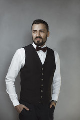 Smiling man in black vest and bow tie