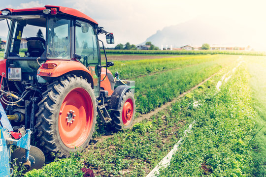 Fototapeta Cut out of tractor cultivating field in spring, agriculture