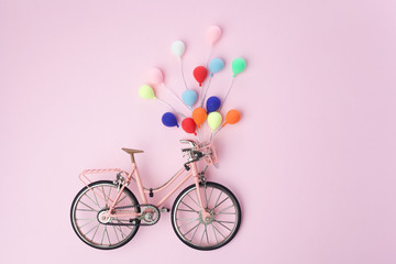 Colorful balloon hang the pink bicycle vintage on pink pastel background. idea of love. Minimal love concept.