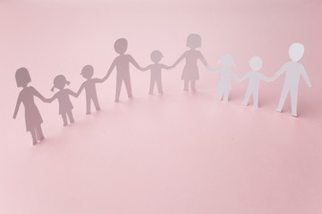 close up of people cut out of paper on pink background